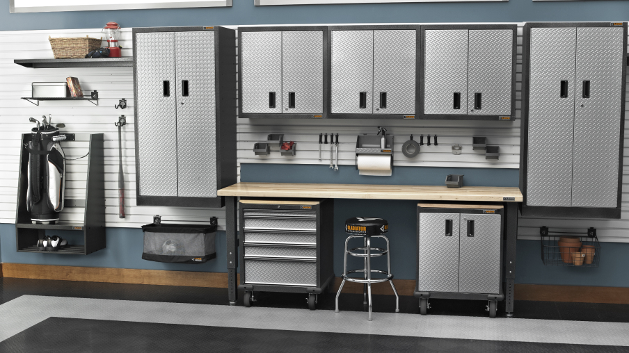 Un garage bien organisé grâce aux armoires de rangement et à l’établi Gladiator. Des bâtons de golf et des chaussures sont soigneusement organisés sur le mur.