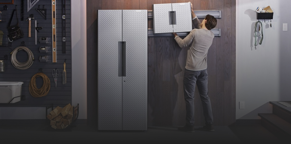A man installs a Gladiator Cabinet on a track as part of the Gladiator Flex Cabinet System