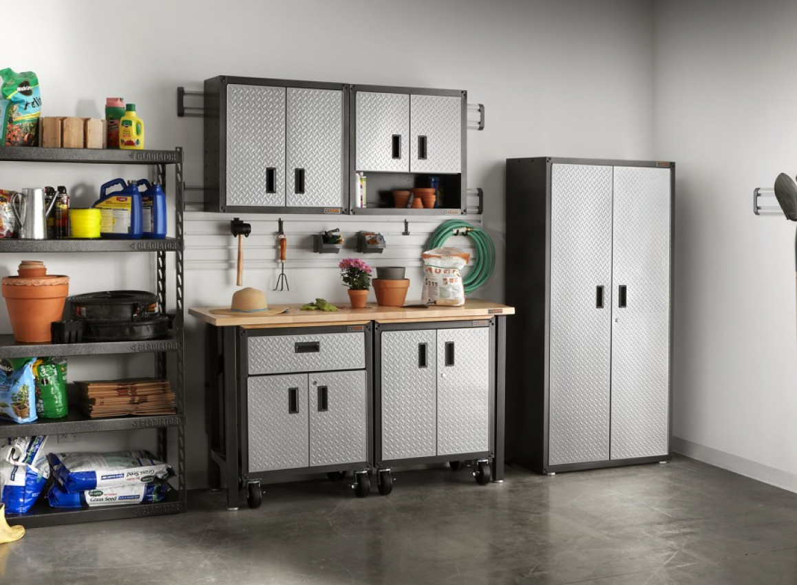 Un garage équipé d'un système d'armoires Gladiator comprenant une armoire à outils Gladiator. Divers articles de jardinage et plantes se trouvent sur une étagère Gladiator