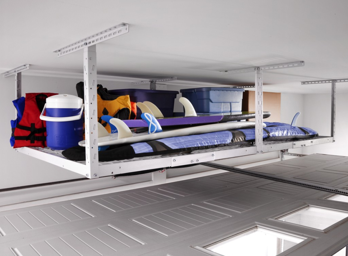 A Gladiator Overhead Storage Compartment holding surf boards, a blue cooler, life jackets, a box and several bins