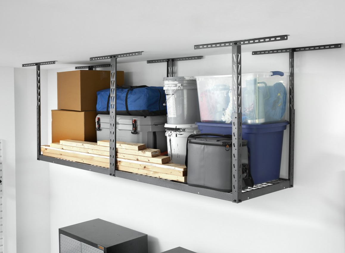 A Gladiator Overhead Storage with stacks of lumber next to a grey cooler and in front of bins, canisters and boxes