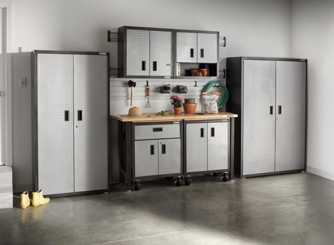A garage with Gladiator Storage Units and Cabinets. On the workbench are potted plants and other items.