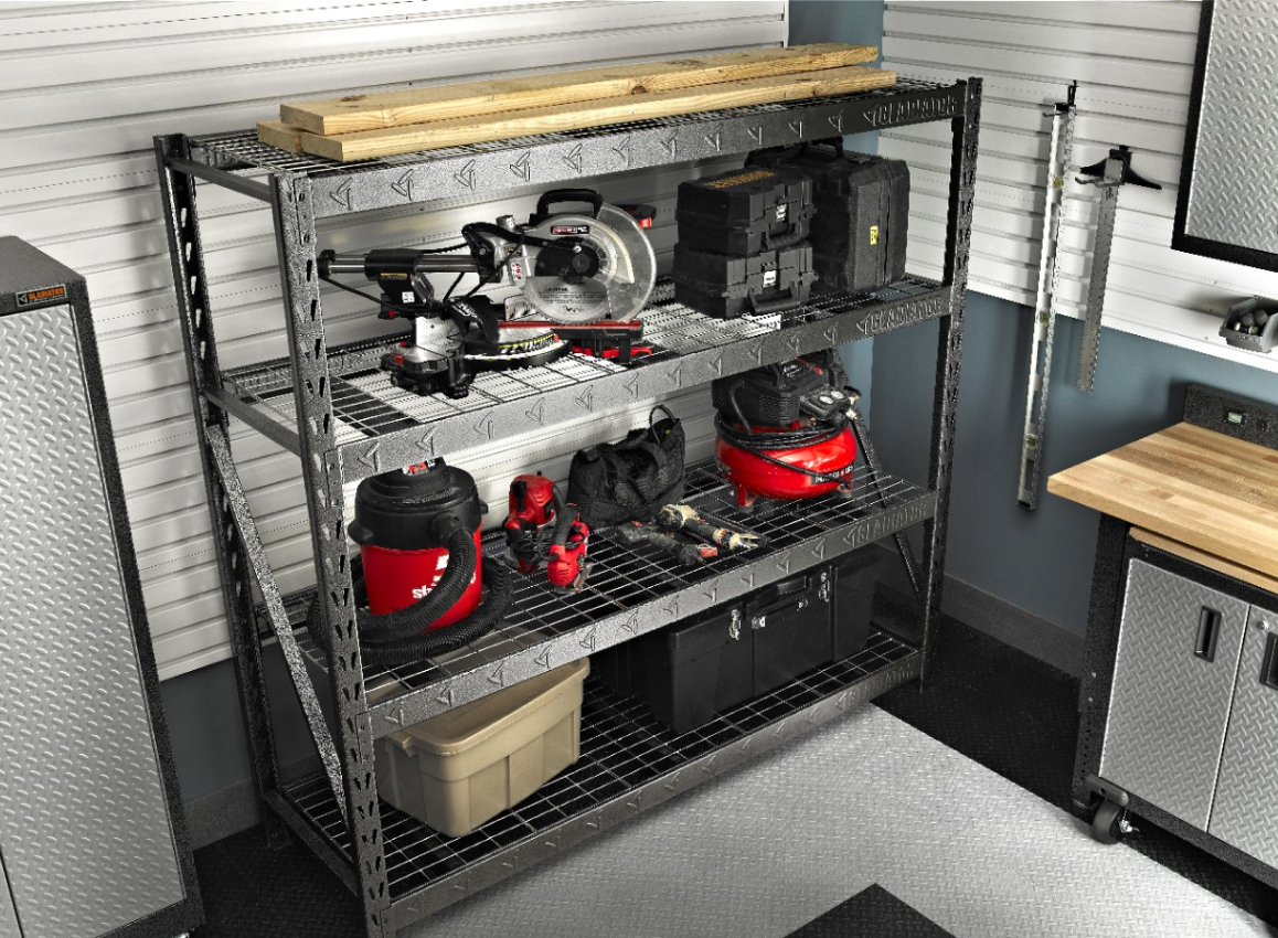 A Gladiator Shelving Unit with vacuums, planks of wood and bins.  Nearby are levels  on the wall, a Gladiator Large GearBox and Gladiator Modular Premier GearBox