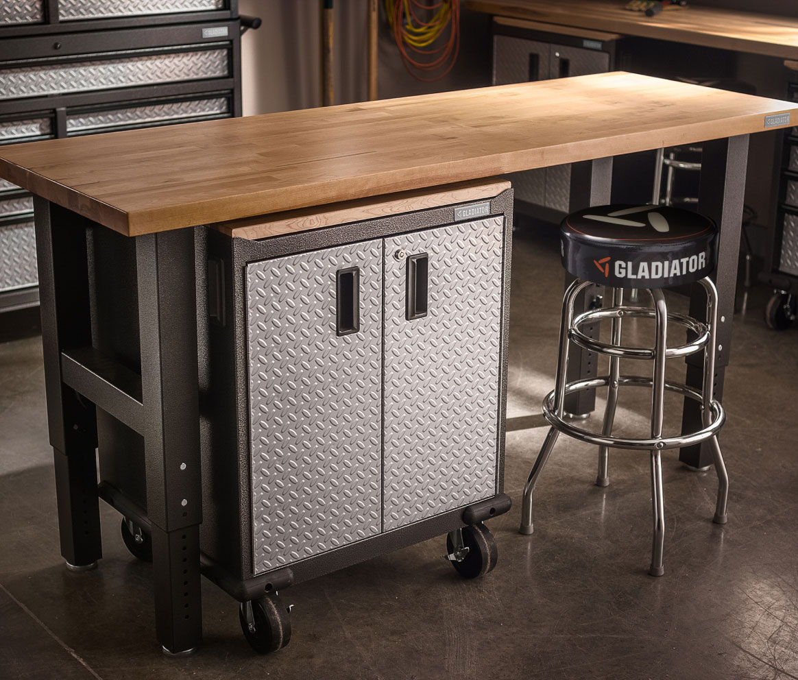 A Gladiator Workbench with a Gladiator Modular Cabinet underneath. There's a stool tucked halfway under the workbench