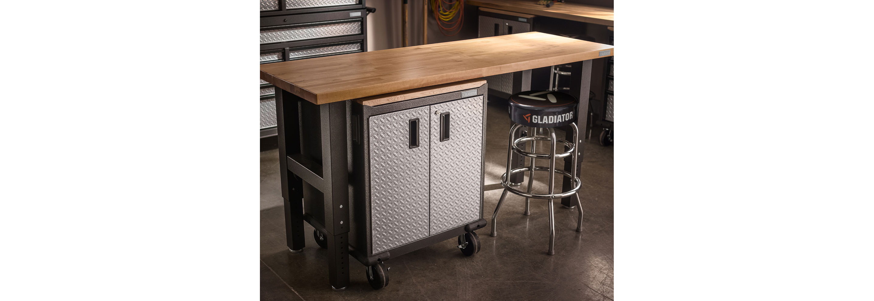 A Gladiator Workbench with a Gladiator Modular Cabinet underneath. There's a stool tucked halfway under the workbench